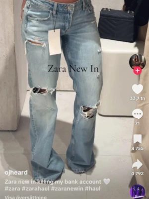 Blå jeans med hål Zara - Trendiga ljusblå jeans med raka ben och flera slitningar på både lår och knän. Jeansen har klassisk femficksmodell och hög midja. Perfekta för en avslappnad och cool stil. Använda 2 gånger