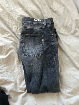 Mörkgrå/Svarta dondup jeans slim fit  - Svarta/Mörkgrå dondup jeans med en riktigt schysst tvätt och ett nypris på runt 3000 kr. Säljer billigt. 