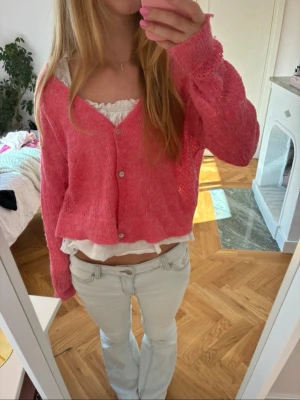 Rosa stickad kofta med knappar - Söt rosa stickad kofta med v-ringning och tre knappar. Materialet är mjukt och lätt, perfekt för lager på lager. OBS en liten fläck och en knapp saknas, men går lätt att lösa ❤️ 