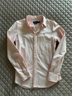 Ralph Lauren skjorta - Säljer nu min ralph lauren skjorta! | Fint skick en liten reva. | Storlek S. | Passar perfekt året runt. | Rosa färg med ränder. | Custom fit. | Släng iväg en signal vid funderingar så svarar jag snabbt. | 