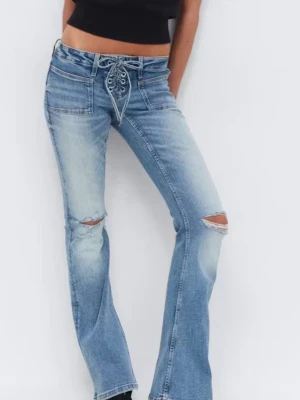 Jeans med snörning - Snygga ljusblå bootcut jeans med snörning i midjan och slitna detaljer vid knäna. Jeansen har en klassisk femficksmodell och är tillverkade i denim med stretch för extra komfort. Perfekta för en trendig och avslappnad look.