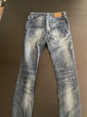 Nudie jeans 27/32 - Säljer ett par blå Nudie jeans i modellen skinny linn, jeansen har riktigt fet och trendig wash. Skriv vid funderingar 