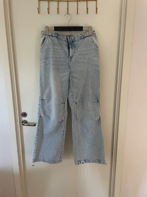 Ljusblåa trendiga vida jeans, stl M-L oanvända  - Säljer ett par ljusblå trendiga jeans. Jeansen är tillverkade i ett mjukt denimtyg. Perfekta för en avslappnad och trendig look. Stl M-L oanvända