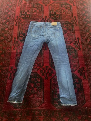 Blå slim fit jeans med raka ben - Snygga blå jeans i slim fit-modell med raka ben och klassiska bakfickor. Jeansen har ljus tvätt och kontrastsömmar. Perfekta till vardagslooken och passar till det mesta. Materialet är denim i bomull.