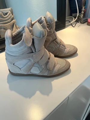 Isabel marant skor  - Säljer mina fina Isabel marant skor. De är i storlek 40 men jag tycker de är lite små (har 48 egentligen). De är använda men fortfarande mycket fina. Har ett hål inuti som jag visar på sista bilden, finns även några små små fläckar i mockan men de går att tvätta bort.