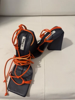 Svarta sandaler med orange snörning - Trendy svarta sandaler från NA-KD med fyrkantig tå och höga blockklackar. De har tunna orange snören som lindas runt foten.