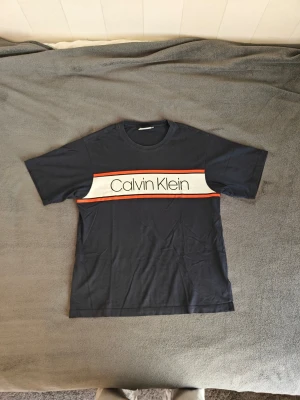 Calvin Klein Tshirt - Mörkblå tshirt i schysst material och stort Calvin Klein tryck över bröstet. Bra passform, inte tajt, inte boxy, perfekt helt enkelt. 100% bomull och nästan oanvänd. Den har bara inte kommit till användning. Kontakta för fler bilder, info eller förhandling! 😎