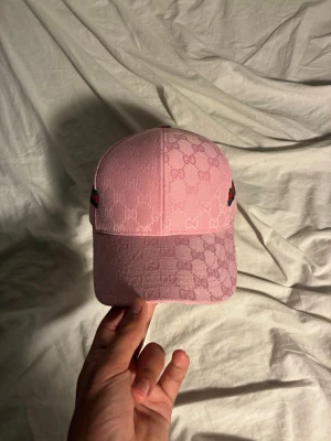 Rosa keps med coolt mönster - En fet rosa keps med rosa mönster och coola detaljer på sidan. Hör av er vid någon fråga!