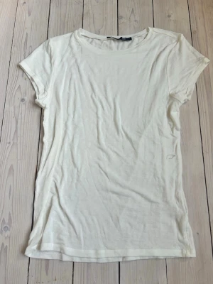 Vit basic t-shirt i bomull - En enkel vit t-shirt med rund hals och korta ärmar, från lager 157 och i storlek L