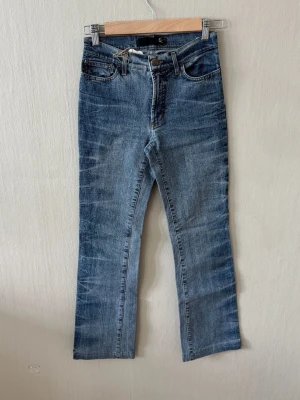 Just Cavalli Blå raka jeans med vintage tvätt - Snygga blå jeans med rak passform och klassisk femficksdesign. Jeansen har en ljusblå vintage tvätt med slitningar och är tillverkade i ett mjukt denimtyg. Perfekta för en avslappnad och trendig look.0087