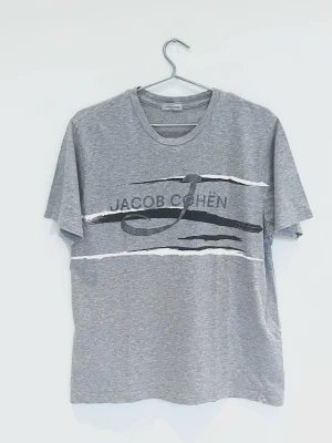 Jacob Cohën T-Shirt - Riktigt fet och sällsynt Tshirt från Jacobcohen! Fint skick, inga tydliga defekter. Storlek M. Kontakta mig för fler frågor och funderingar!