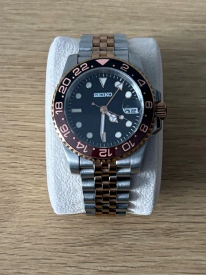Seiko Mod Klocka - Säljer en väldigt snygg seiko mod i färgen silver/rosegold, den har självlysande visare och nummer i mörker och storleken kan justeras vid armbandet. Den drivs av ett automatiskt urverk Klockan är i hyvsat bra skick men ändå täcken på användning. Pris kan diskuteras vid snabb affär!💨