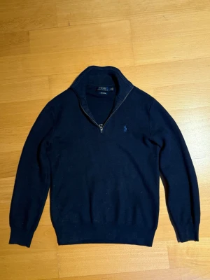Mörkblå stickad tröja från Polo Ralph Lauren - Mörkblå stickad tröja från Polo Ralph Lauren med halvzip och långa armar. Priset är inte hugget i sten🙌