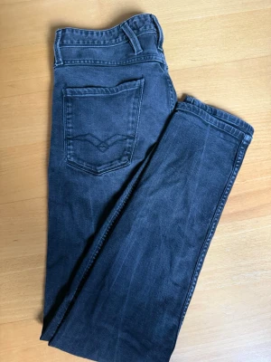 Gråa Slim Fit Jeans Replay - Snygga mörkblå slim fit jeans från Replay med klassisk färg och diskret wash. Jeansen har raka ben och är tillverkade i mjukt denimtyg som ger en skön passform. Perfekta för dig som gillar en stilren och enkel look. Priset är inte hugget i sten🙌
