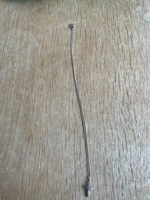 Silverhalsband med korshänge - Snyggt halsband i silverfärgad metall med ett korsformat hänge. Kedjan är tunn och smidig, och korset har en enkel, stilren design med en liten detalj i mitten. Perfekt för dig som gillar minimalistiska smycken med en personlig touch. Äkta silver har inte använts på några år de förklarar varför den har börjat rosta