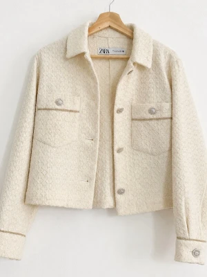 Unik bouchéjacka från ZARA - Stilren krämvit jacka från ZARA med strukturerat tyg, dekorativa silverknappar och två bröstfickor. Kortare modell med klassisk krage och långa ärmar. Perfekt för lager på lager och trendig look.