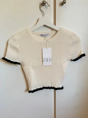 Tröja Zara - Stickad T-shirt från Zara, i kortare modell. Aldrig använt, prislappen sitter kvar.