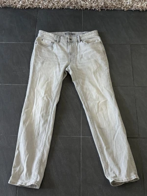 Ljus grå Dressman Jeans 32/32  - Oanvända Grå Jeans från Dressman. Modellen heter ”Nevada stretch Jeans” och kostar 600kr ny. Storleken är i 32/32 och passar dig perfekt om du är 175-180, och runt 70kg. Anledningen varför jag säljer är för att dem lite för stora i midjan just för mig så har inte kommit till nån användning. 