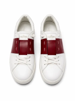 Valentino sko - Snygga sneakers från Valentino i vitt läder med bred röd panel över snörningen. Skorna har klassisk låg profil, vita snören och dekorativa nitar på hälen. Perfekta för dig som vill ha en stilren men ändå unik look.