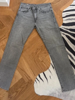 Grå raka jeans med fem fickor - .Klassiska grå Levi’s Premium-jeans i mycket fint skick. Straight fit, normal passform och storlek W32/L34. Tidlösa och passar perfekt både till vardags och speciella tillfällen. Hög kvalitet och lättmatchade. 
