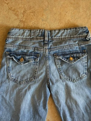 Ljusblå jeans - Säljer ett par ljusblå vida jeans. Jeansen är i väldigt bra skick. De har  dubbla knappar fram och ficklock med knapp bak. Jeansen har klassisk femficksdesign. Perfekta för en avslappnad och trendig look. Hör av dig om du har frågor!💕