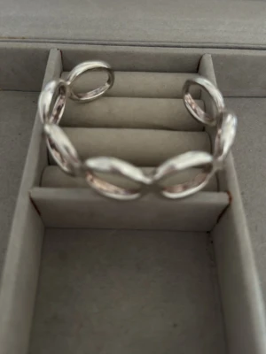 Äkta silverarmband med länkar - Säljer ett stilrent armband i silverfärg med stora, ovala länkar. Armbandet har en öppen design och är tillverkat i metall. Perfekt för dig som gillar minimalistiska och trendiga accessoarer. Stämpeln 925 är en så kallad finhaltsstämpel som visar att smycket är tillverkat av äkta sterlingsilver. Siffran innebär att armbandet består av 92,5 % rent silver, medan resterande 7,5 % vanligtvis är koppar som tillsätts för att göra metallen tillräckligt hård och slitstark för smyckestillverkning.