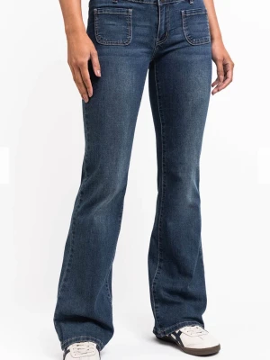 Mörkblå bootcut jeans med fickor - Säljer ett par mörkblå bootcut jeans med två stora framfickor och klassisk femficksdesign. Jeansen har hög midja och utsvängda ben, vilket ger en retrovibe. Tillverkade i mjuk denim med snygg tvätt och kontrastsömmar.