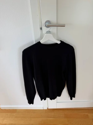 Svart stickad tröja  - Svart stickad tröja. Storlek XS. Litet hål i nacken. 