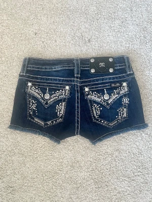 Lågmidjade Miss Me jeansshorts - Säljer ett par mörkblå jeansshorts från Miss Me med storlek S. Den har låg midja och är perfekta för sommaren✨ Midjemått: ca 71 cm Priset kan diskuteras och skriv gärna vid frågor!💕 Säljanledning: för små storlek