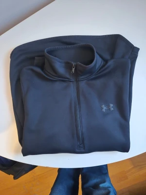 Svart halv ziptröja från Under Armour - Storlek S 