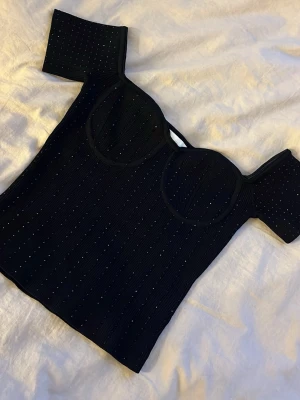 Svart glittrig topp från h&m - Skit snygg svart topp från h&m i strl XS!!