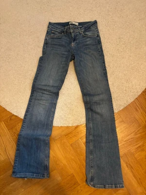 Blå bootcut jeans från ZARA - Säljer ett par blå bootcut jeans från ZARA i storlek 34. De är i mycket bra skick och har inga defekter.
