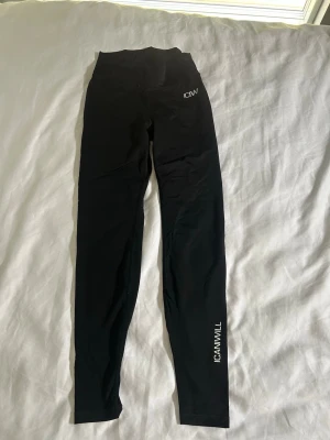 Svarta leggings från ICANIWILL - Säljer ett par svarta leggings från ICANIWILL med hög midja och scrunch-detalj bak. Tight passform och stretchigt material som sitter snyggt, perfekta att gymma i då dom sitter på sin plats. Bra skick.