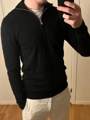 Matinique halv zip - Säljer en svart matinique halv zip i 100% merino i storlek s. Personen på bilden är ca 180