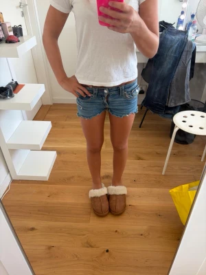 Blå jeansshorts med knappar - Blåa jeans shorts i storlek 152. Jag själv som klippt de från ett par gina tricot jeans. Fint skick och uppsprättade små ”hål”. Går att spänna i midjan.