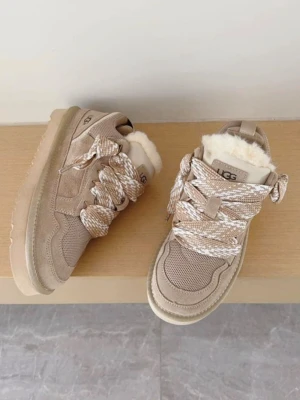 Beige sneakers från UGG med foder - Snygga beige sneakers från UGG med grova snören och fluffigt vitt foder. Skorna har en blandning av mocka och meshmaterial, samt en rejäl sula för extra komfort. Perfekta för dig som vill ha både stil och värme i ett par sneakers.