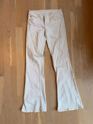 Vita bootcut jeans - Säljer ett par vita bootcut Cheap Monday jeans från Weekday med klassisk femficksdesign. Perfekta för dig som vill ha en clean och stilren look. Storlek 28/32