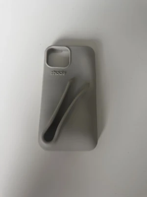 Grått mobilskal Rhode - Snyggt grått mobilskal från Rhode. iPhone 13. Har ett litet hack på sidan men som inte märks av när man sätter på det:) kommer inte med ett läppglans 