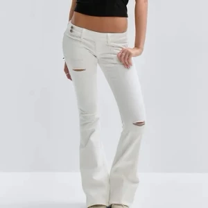 Vita bootcut jeans med slitningar - Säljer ett par vita bootcut jeans med snygga slitningar vid knä och lår. Jeansen har låg midja, klassisk femficksmodell och utsvängda ben. Perfekta för dig som vill ha en trendig och avslappnad look.