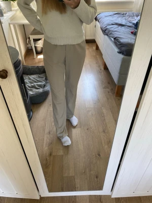 Beiga raka kostymbyxor - Snygga beiga kostymbyxor med rak passform och hög midja. Byxorna har en klassisk look med diskret knapp och dragkedja framtill. Perfekta för en clean och stilren outfit. Materialet är mjukt och följsamt, därav väldigt bekvämt. Det står att byxorna är i storlek 36 men dem är förstora för mig som vanligtvis har det, så skulle säga dem är nån storlek större. 