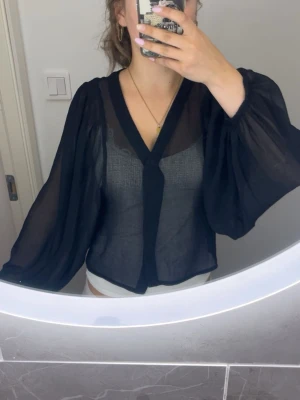 Svart transparent blus med vida ärmar - Snygg svart blus i transparent material med vida, ballongformade ärmar och v-ringning. 💖