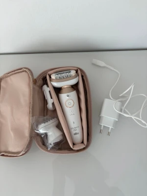Braun Silk-épil 9 epilator med tillbehör - Säljer en vit och guld Braun Silk-épil 9 epilator med tillbehör, laddare och en beige förvaringsväska. Använt en gång på prov men jag hade inte smärttåligheten för det😅 därför säljer jag den. Men min vän har en likadan som hon älskar så det är bevisligen olika det där med smärttåligheten😂. Så den är i princip i nyskick! Allt är smidigt packat och perfekt för att ta med på resan. Epilatorn har ergonomisk form och tillbehören är i plast.