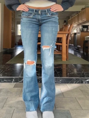 Guess jeans - Jag säljer mina jätte snygga blå guess jeans med hål på båda benen med  Innerben 83cm midja rakt över 39cm🩷