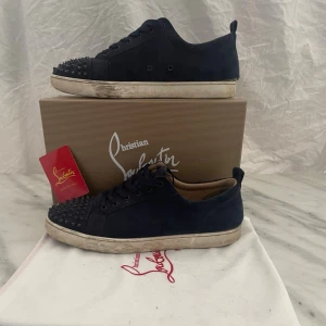Mörkblå Christian Louboutin sneakers - Skorna är slitna har slitit sönder i bak på högra foten går att fixa hos en skomakare för 350kr 