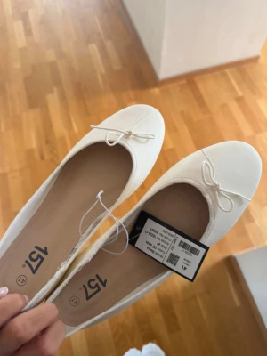 Vita ballerinaskor med rosett - Säljer ett par vita Ballerina skor från lager 157, jätte fina och söta. Säljer på grund av att det är lite för stora, slut på hemsidan🥰