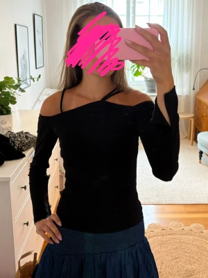 Svart offshoulder topp med band - En jättefin svart offshoulder topp med långa ärmar och fina dekorativa, asymmetriska axelband. Längst ner vid ärmarna fins en slits som detalj. Från Gina Tricot, storlek S💗Tyvärr har den ett litet hål längst ner på en av ärmarna, men det är absolut inget man tänker på (sista bilden). Annars är den i ett bra skick. Kontakta om du har frågor💗
