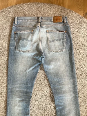 Nudie Jeans lean dean  - Säljer ett par riktigt schysta jeans av Nudie I modellen Lean Dean som har en klassisk slim fit passform. Dem har en snygg snusdosefade samt lagningar av nudie själva som är riktigt snygga. W31 och L30 men dem är mer som L32 då dem är 103cm långa 