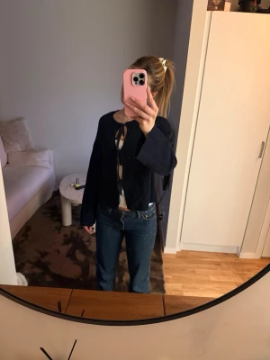 Kofta med knyt där fram - En mörkblå kofta med tre knyten där fram. Kan användas med eller utan linne under