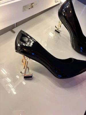 Klackskor - OBS EJ RÄTT STORLEK, läs . Supersnygga svarta klackskor med guldig klack som är formad som YSL. Tyvärr alldeles för små för mig. Märkta 42 men flera storlekar mindre. Hela innermått är ca 27,5cm men passar någon med ca 24,5-26cm fot pga modellen. (Strl 39/40?) Utgå infrån cm måttet och utifrån vilken passform du önskar. Klackhöjd ~8cm. Säljs utan kvitto. Skriv gärna för hjälp med storleken om det skulle behövas🩷