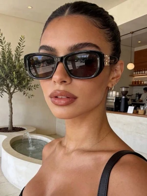 Nya Svarta solglasögon  - Snygga svarta solglasögon med rektangulära bågar och guldfärgade detaljer vid skalmarna. Glasögonen har en chunky design och mörka linser som ger en cool och trendig look.